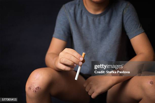 young boy with cigarette in hand - boys smoking cigarettes stock pictures, royalty-free photos & images
