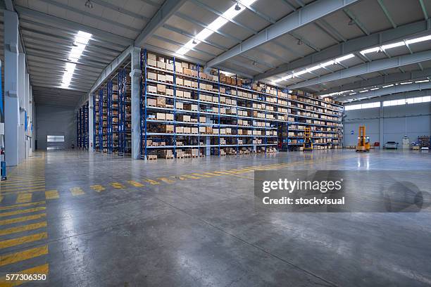 cardboard boxes on shelves in warehouse - opslagruimte stockfoto's en -beelden