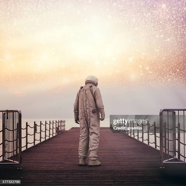 einsamer astronaut am strand - conceptualrealismtrend stock-fotos und bilder