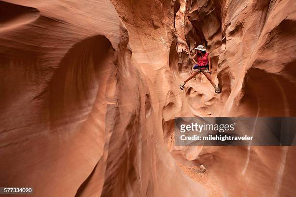 woman climbing and hiking slot canyons escalante utah horizontal - escalante canyons bildbanksfoton och bilder