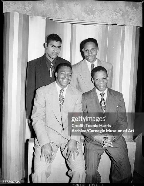 Group portrait of Schenley High School football players Henry 'Hank' Ford, Charlie 'Mule' Hill, Donald Miller, and James Robinson, posed in front of...