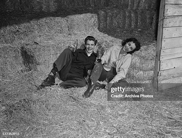 Actors Scotty Beckett and Elizabeth Taylor pose for a publicity shot set in a barn, circa 1948.
