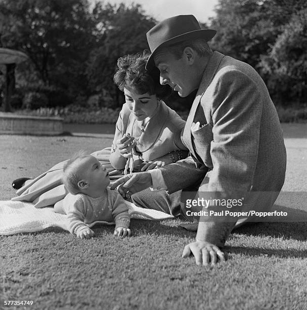Actors Elizabeth Taylor and her husband, Michael Wilding with their baby son, Michael Howard Wilding, in Hyde Park, London, October 1953.