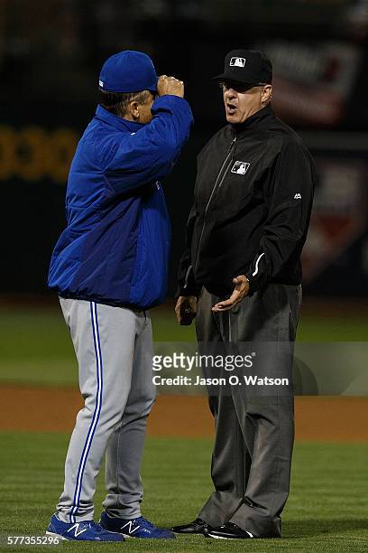 John Gibbons of the Toronto Blue Jays argues with umpire Paul Emmel during the eighth inning against the Oakland Athletics at the Oakland Coliseum on...