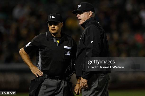 Umpire Paul Emmel talks to Mark Wegner during the eighth inning between the Oakland Athletics and the Toronto Blue Jays at the Oakland Coliseum on...