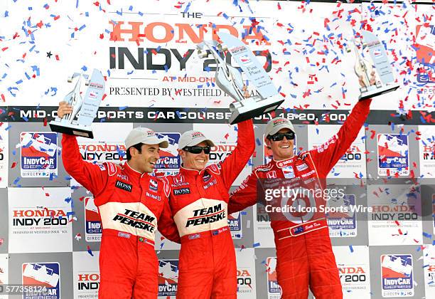 Driver Helio Castroneves, Ryan Briscoe and Scott Dixon celebrate after the Honda Indy 200 at Mid Ohio.