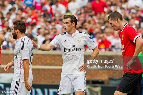 Real Madrid forward Gareth Bale, center, reaches out to defender Daniel Carvajal, left, as Manchester United defender Michael Keane, right, walks by...