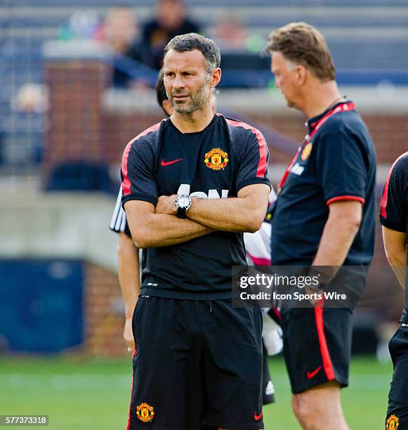 Manchester United assistant manager Ryan Giggs, left, watches his team on the field during a training session at Michigan Stadium in Ann Arbor,...
