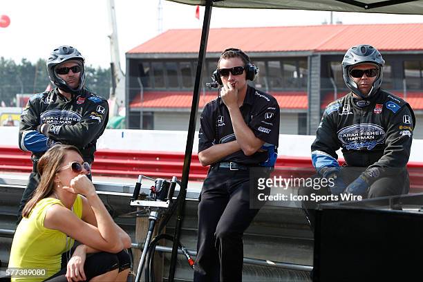 Crew members of IndyCar Driver Josef Newgarden look on in disbelief after they were assessed a black flag penalty which resulted in their team...