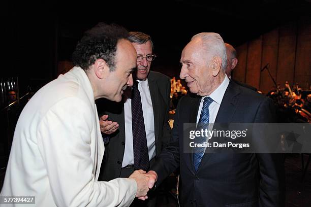 French conductor and Music Director of the Jerusalem Symphony Orchestra Frederic Chaslin shakes hands with former Israeli President Shimon Peres...