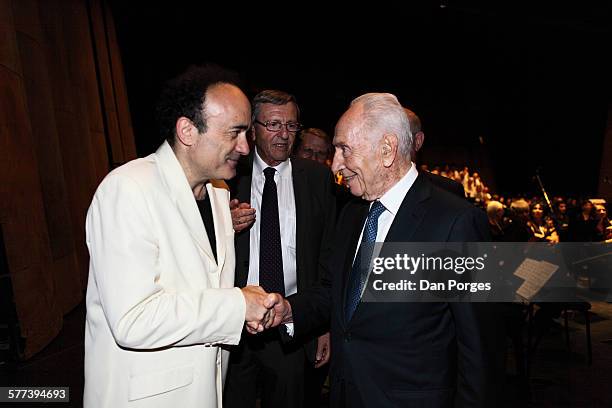 French conductor and Music Director of the Jerusalem Symphony Orchestra Frederic Chaslin shakes hands with former Israeli President Shimon Peres...