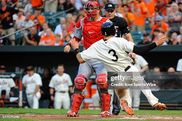 Baltimore Orioles third baseman Ryan Flaherty scores as St. Louis Cardinals catcher A.J. Pierzynski waits for the late throw at Orioles Park at...