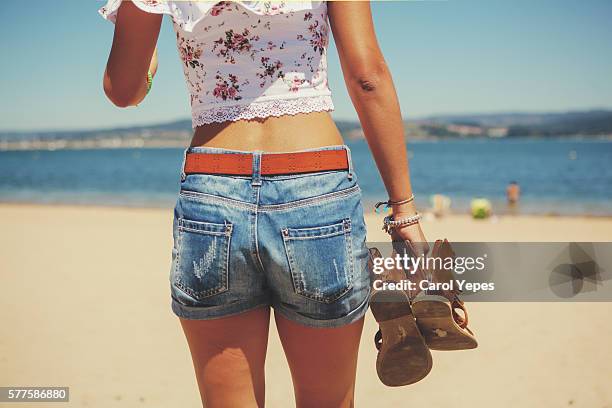 rear view  woman walking in beach.shots pants. - denim shorts fotografías e imágenes de stock