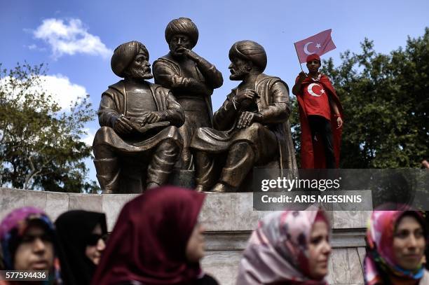 Boy waves a Turkish flag near Sultan Mehmed II statue during a demonstration in support to the Turkish President at the Sarachane park in Istanbul on...