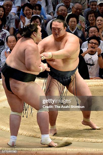 Ozeki Kisenosato pushes Mongolian ozeki Terunofuji out of the ring to win during day nine of the Grand Sumo Nagoya Tournament at the Aichi Prefecture...