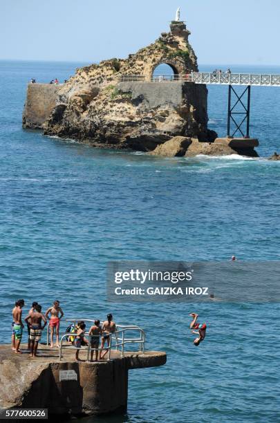 People enjoy the sunny weather on the "La Plage du Port-Vieux" beach next to the "Rocher de la Vierge" in Biarritz, southwestern France, on July 19,...