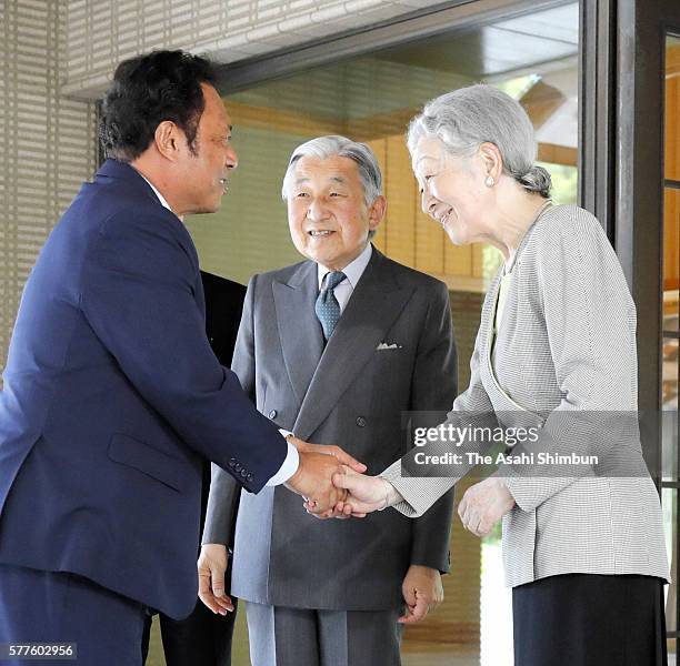 Palau President Tommy Remengesau shakes hands with Empress Michiko while Emperor Akihito watches during their meeting at the Imperial Palace on July...