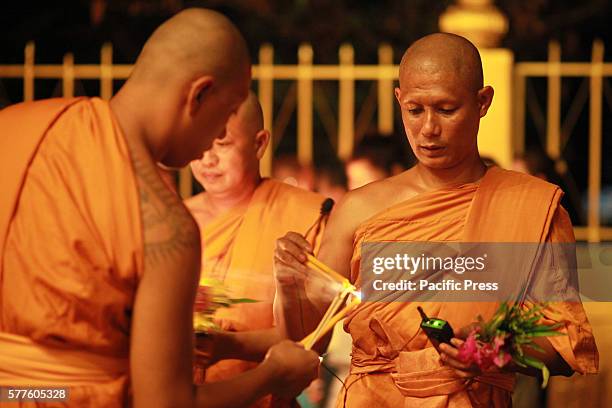 Thai monks holding candles during Asalha Puja Day celebration. Thai culture or Asalha Puja Day celebrates the first teaching of Buddha. Asalha is...