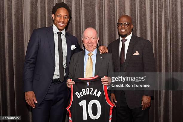 DeMar DeRozan of the Toronto Raptors pose for a photo with Agent, Aaron Goodwin and Larry Tanenbaum, Chairman of Maple Leaf Sports & Entertainment,...