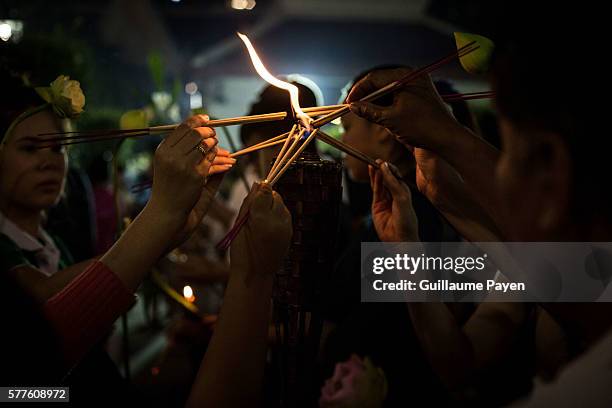 Buddhists devotees light incense at Wat Pathum Temple to celebrate Asana Bucha Day know as Buddhist Day. The day is observed on the full moon of the...