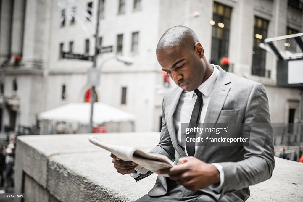 Business man reading a newspaper on nyc