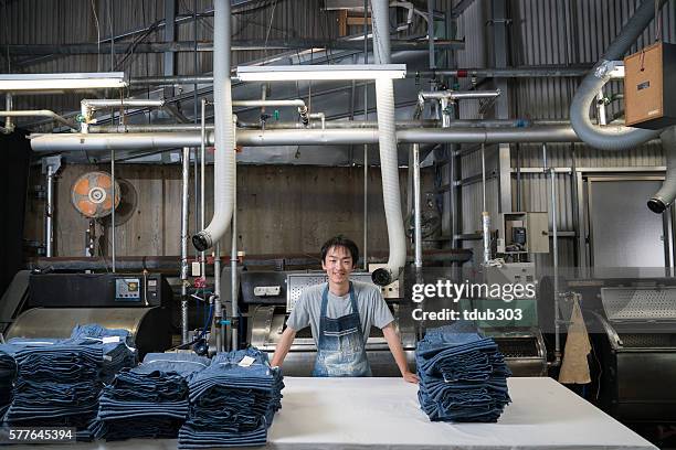 textile industry worker checking inventory before shipping - textielfabriek stockfoto's en -beelden