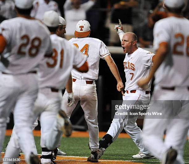 Players race to home plate as University of Texas Longhorns catcher Preston Clark crosses home plate in the 9th inning against the Army Black Knights...