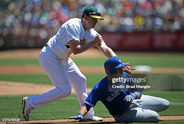 Josh Thole of the Toronto Blue Jays is tagged out by Oakland Athletics third baseman Ryon Healy after getting caught in a rundown between third and...