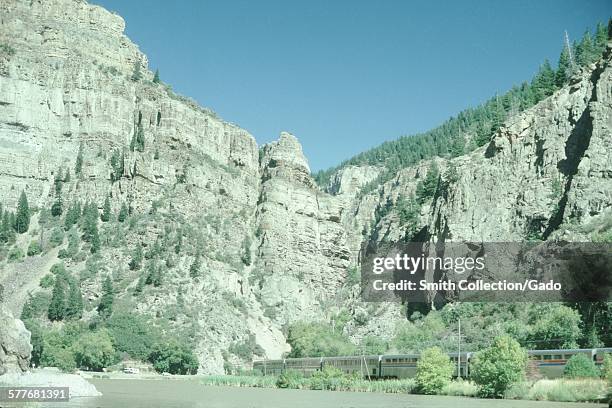 Amtrak train traveling through rocky terrain in the desert, Southwest United States, 1969.