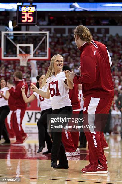 Wisconsin dance team member dances with a member of the Wisconsin Badger football team during a timeout, as the Wisconsin Badgers defeated the 9th...