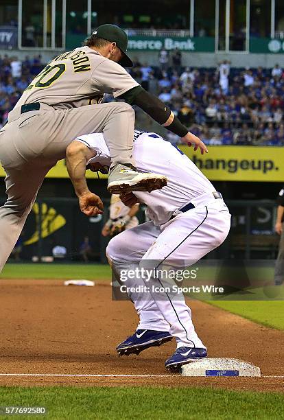 Oakland Athletics' third baseman Josh Donaldson ca't handle a high throw and Kansas City Royals' designated hitter Josh Willingham is safe stealing...