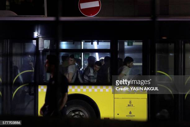 Bus detaining Turkish soldiers who allegedly took part in a military coup arrives at the courthouse in Istanbul as a Turkish anti-riot police officer...
