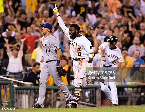 Josh Harrison of the Pittsburgh Pirates celebrates as he heads towards home plate after hitting a triple and comes in to score on a throwing error by...
