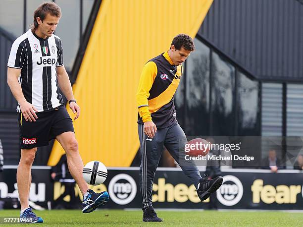 Ivan Maric of the Tigers, a soccer fanatic, gets to kick a soccer with Hernanes of Juventus who kicks an AFL football during a Richmond Tigers AFL...