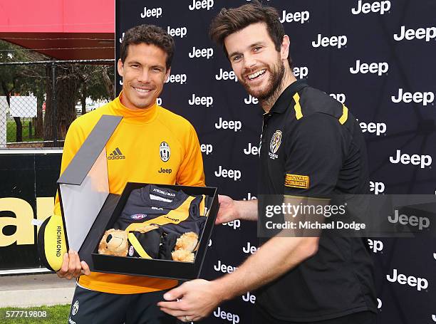 Trent Cotchin of the Tigers presents a gift to Hernanes of Juventus during a Richmond Tigers AFL and Juventus FC media opportunity at Punt Road Oval...