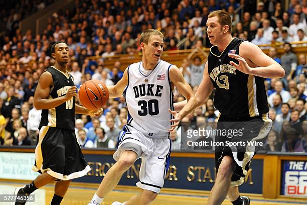 Duke guard Jon Scheyer drives past Wake Forest center Chas McFarland during a game between the Wake Forest Demon Deacons and the Duke Blue Devils at...