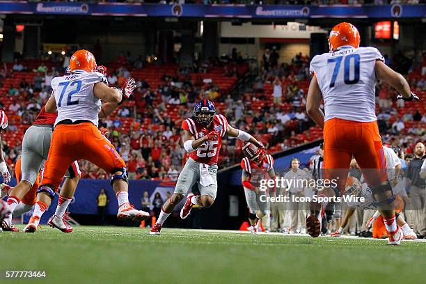 Mississippi Rebels defensive back Cody Prewitt looks for yardage after an interception as he is pursued by Boise State Broncos offensive linesman...
