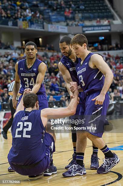 Teammates help up Northwestern Wildcats center Alex Olah during the Big Ten Men's Basketball Tournament game between the Iowa Hawkeyes vs...