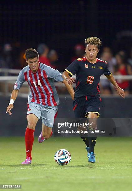 Maryland Tsubasa Endoh pulls ahead of Louisville Romilio Hernandez during a NCAA soccer match at Lynn Stadium, in Louisville, Kentucky.