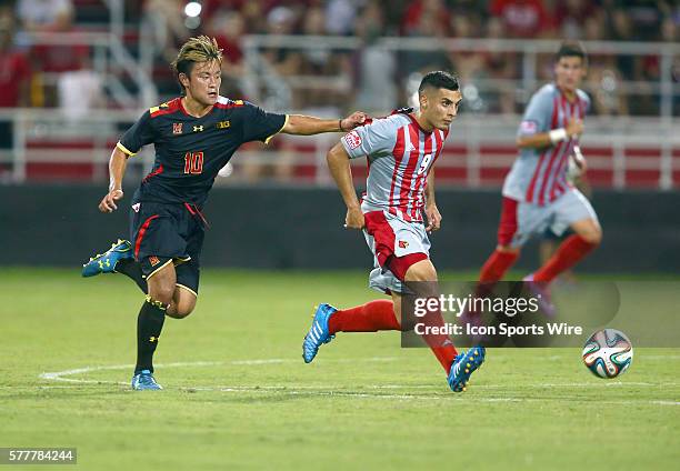 Maryland Tsubasa Endoh grabs hold of Louisville Ricardo Velasco during a NCAA soccer match at Lynn Stadium, in Louisville, Kentucky.