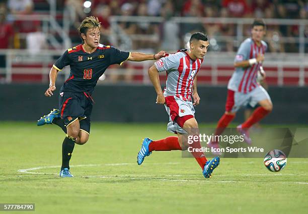 Maryland Tsubasa Endoh grabs hold of Louisville Ricardo Velasco during a NCAA soccer match at Lynn Stadium, in Louisville, Kentucky.