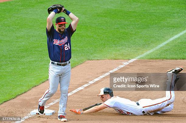 Baltimore Orioles third baseman Ryan Flaherty slides into third base with a triple as Minnesota Twins third baseman Trevor Plouffe waits for the...