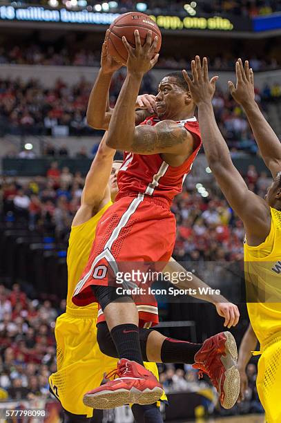 Ohio State Buckeyes guard Lenzelle Smith, Jr. Is fouled by Michigan Wolverines guard Nik Stauskas during the Big Ten Men's Basketball Tournament game...