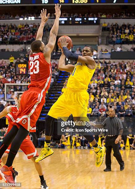 Glenn Robinson III of the Michigan Wolverines try's to pas the ball around Amir Williams of the Ohio State Buckeyes during the game between against...