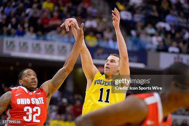 Michigan Wolverines guard Nik Stauskas takes a three point shot past Ohio State Buckeyes guard Lenzelle Smith Jr. During the Big Ten Men's Basketball...