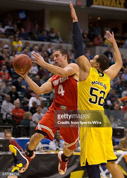 Aaron Craft of the Ohio State Buckeyes going for a lay up around Jordan Morgan of the Michigan Wolverines during the game between against the Ohio...