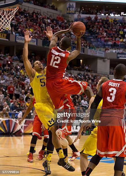 Jordan Morgan of the Michigan Wolverines guarding Sam Thompson of the Ohio State Buckeyes as his goes for a lay up during the game between against...