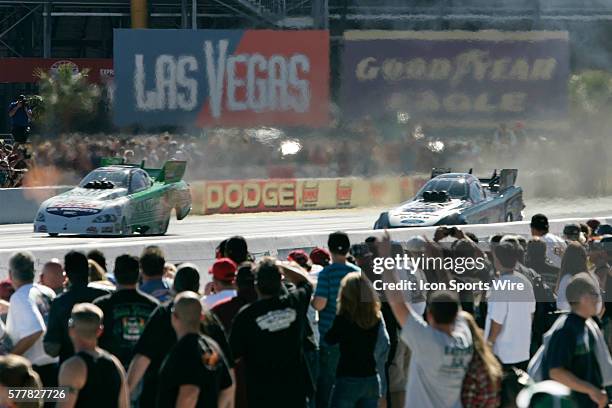 Fans watch as Paul Lee, left, and Ashley Force Hood race during the finals of the 2010 NHRA Las Vegas Nationals Sunday, October 31, 2010 at the Las...