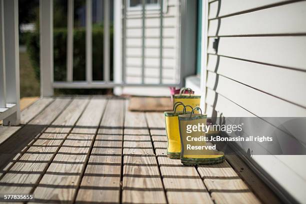 kids boots on the porch - jc bonassin stock pictures, royalty-free photos & images
