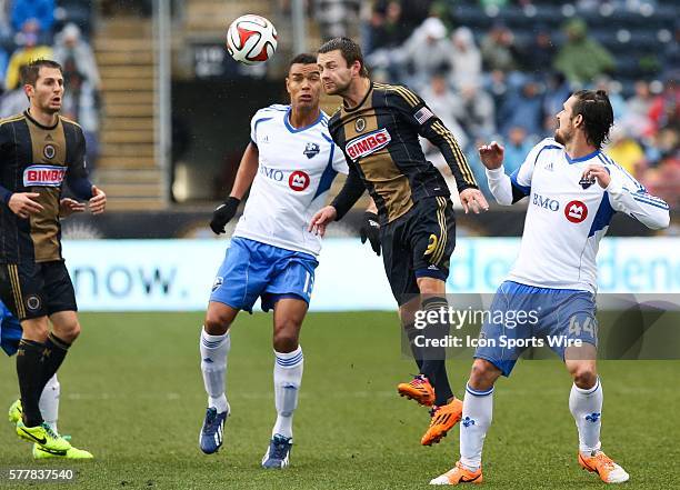 Philadelphia Union forward Jack McInerney heads the ball past Montreal Impact defender Heath Pearce and defender Matteo Ferrari during an MLS game at...